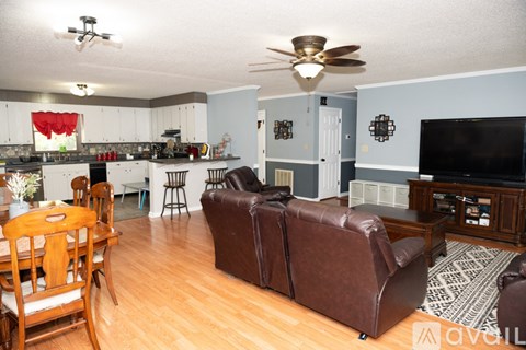 A living room with a brown leather couch and a wooden table.