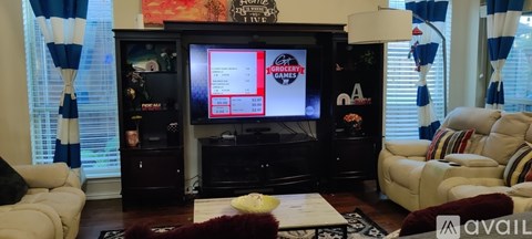 A living room with a television on a black entertainment center.
