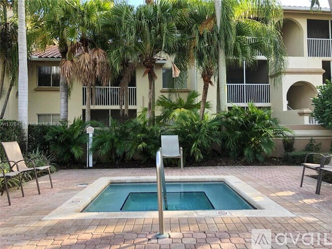 A pool surrounded by palm trees and plants.
