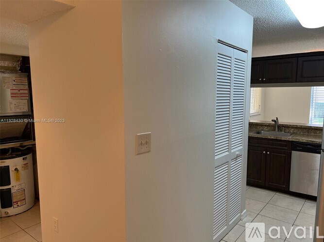 A white closet with a sliding door is in a kitchen.