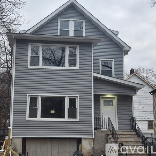 A grey house with a white door and windows.