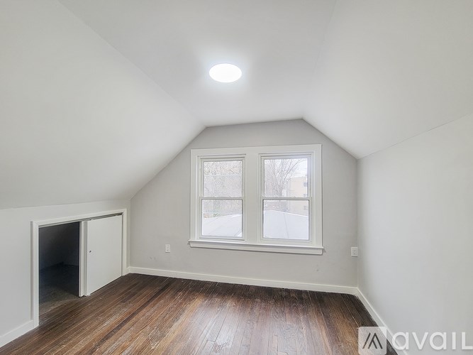A room with a window and a door is available for rent.
