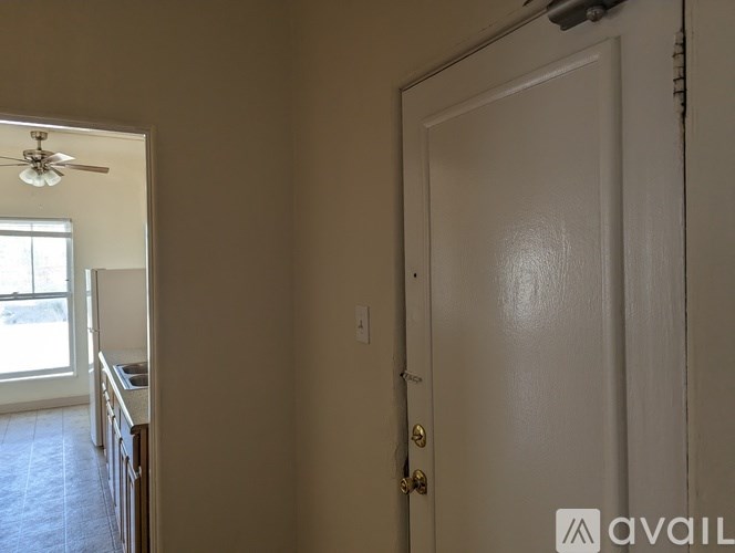A white door is closed in a room with a fan on the ceiling.