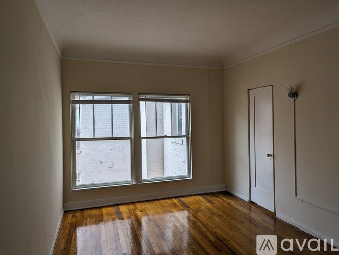 A room with wooden floors and a large window.