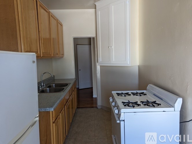 A kitchen with a white fridge, a white stove, and wooden cabinets.
