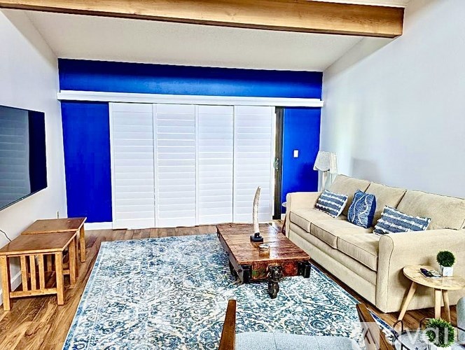 A living room with a couch, a coffee table, and a rug.
