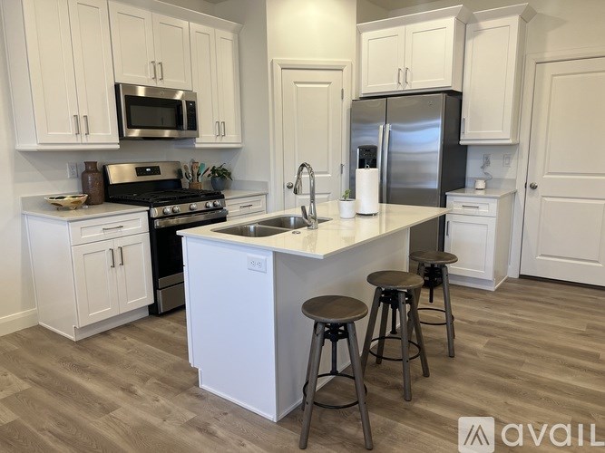 A kitchen with white cabinets and a wooden floor.