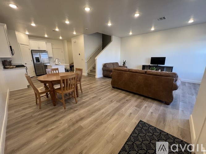 A living room with a brown couch and a wooden table.
