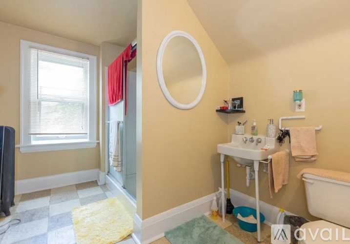 A bathroom with a tub, sink, and window.