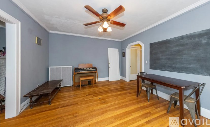 A room with a ceiling fan and wooden flooring.