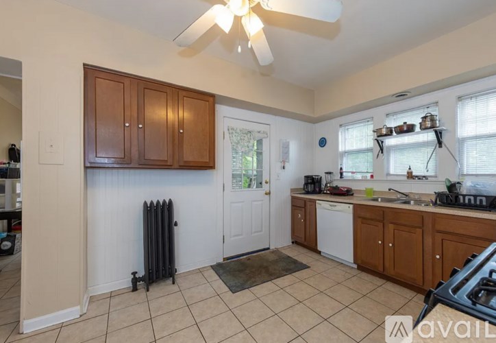 A kitchen with a white door and brown cabinets.