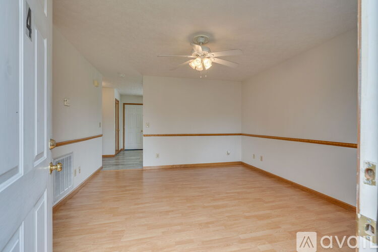 A room with wooden floors and a ceiling fan.