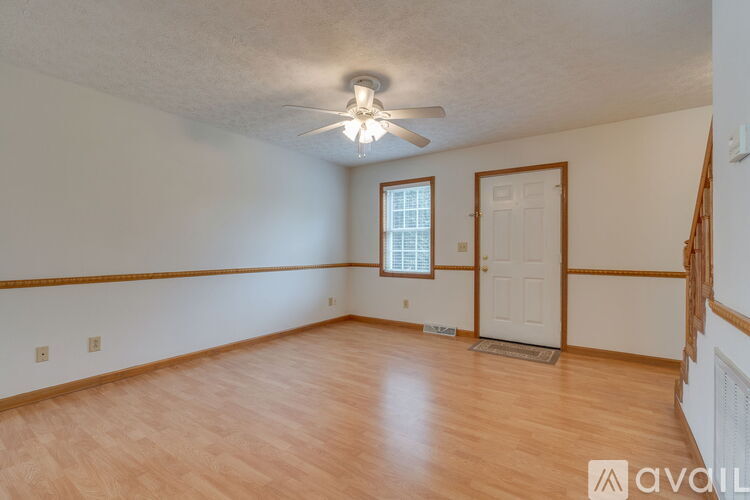 A room with wooden flooring and a ceiling fan.