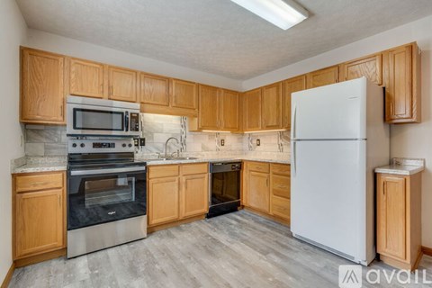 A kitchen with wooden cabinets and a white refrigerator.