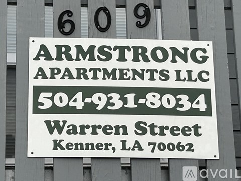 A sign for Armstrong Apartments LLC is displayed on a building.