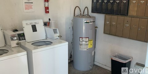 A washing machine and a water heater in a small room.