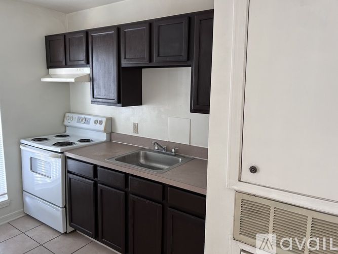 A kitchen with black cabinets and a white stove.