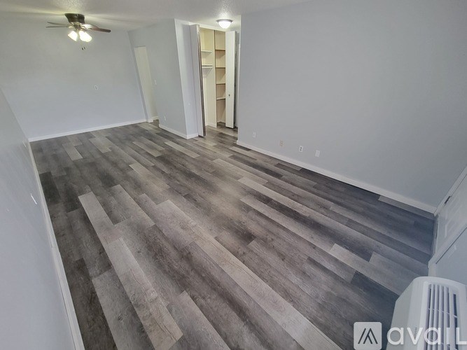 A room with wooden flooring and a ceiling fan.