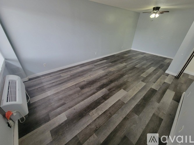 A room with wooden flooring and a ceiling fan.