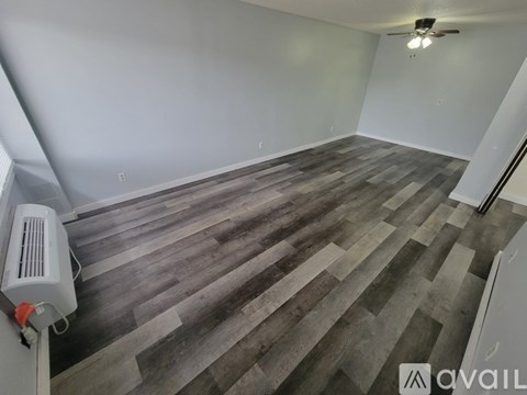 A room with wooden flooring and a ceiling fan.