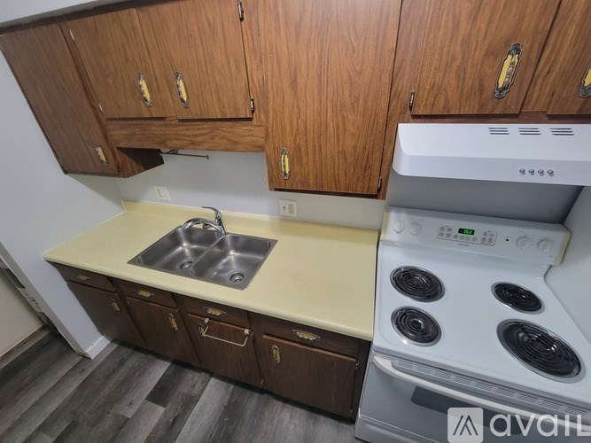 A kitchen with wooden cabinets and a white oven.