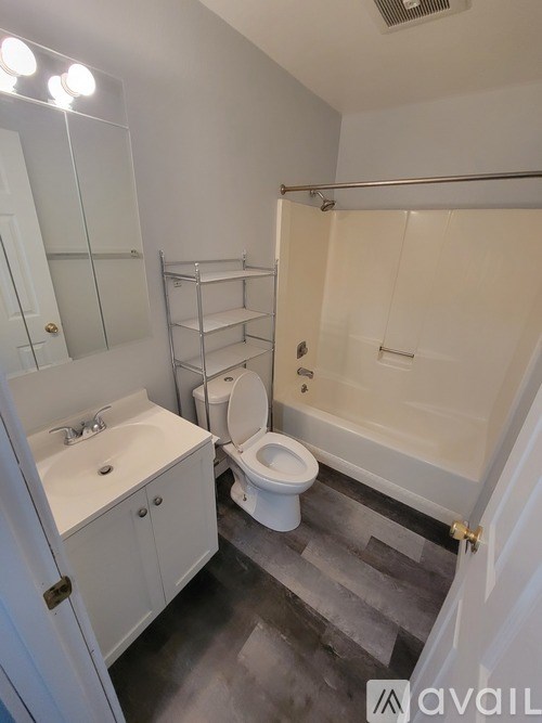 A bathroom with a toilet, sink, and bathtub.