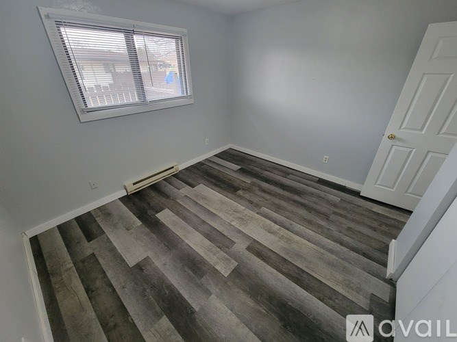 A room with wooden flooring and a window.