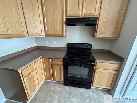 A kitchen with wooden cabinets and a black stove top oven.