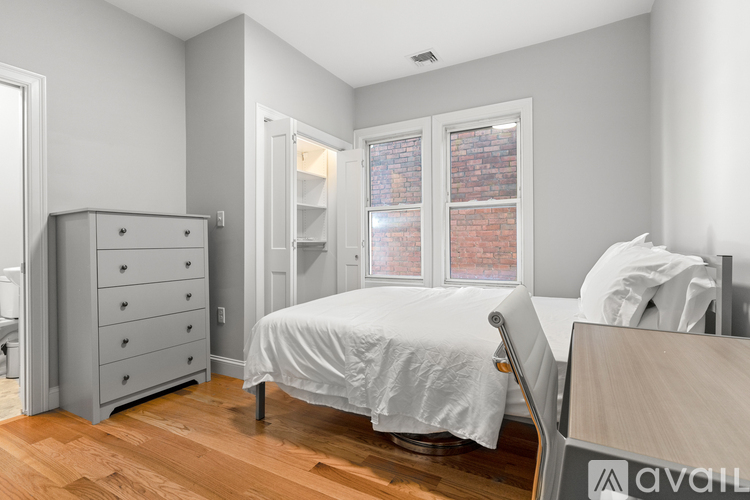 A bedroom with a bed, desk, and chair.