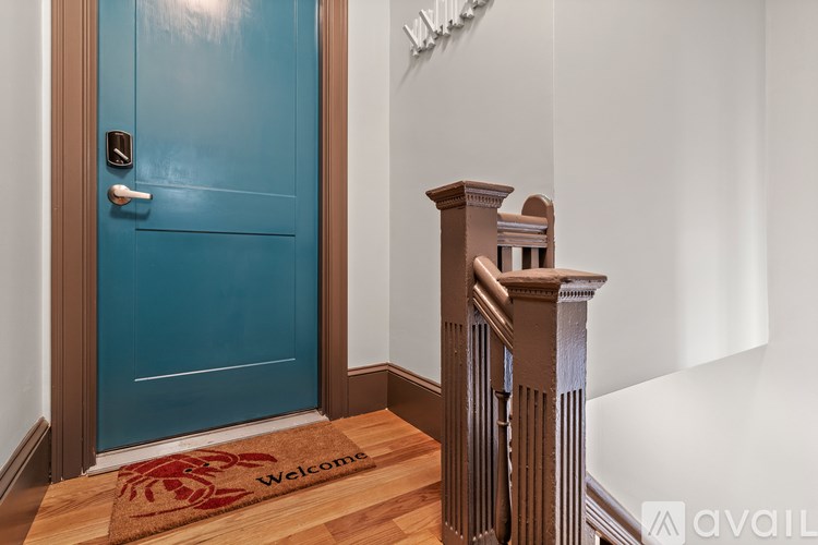 A blue door with a welcome mat in front of it.