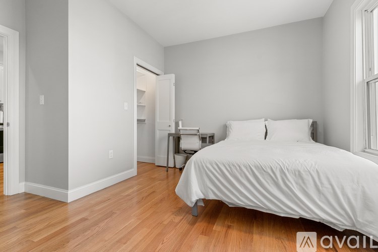 A bedroom with a bed, nightstand, and chair.