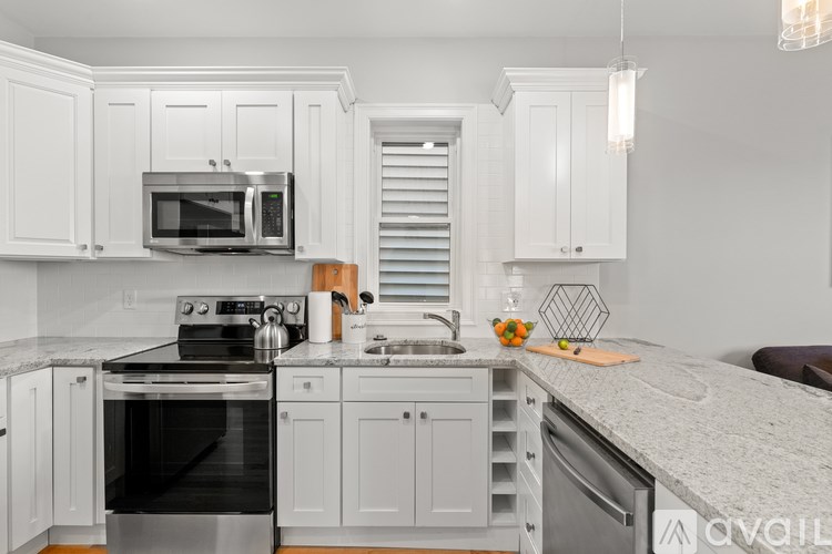 A kitchen with white cabinets and a granite countertop.