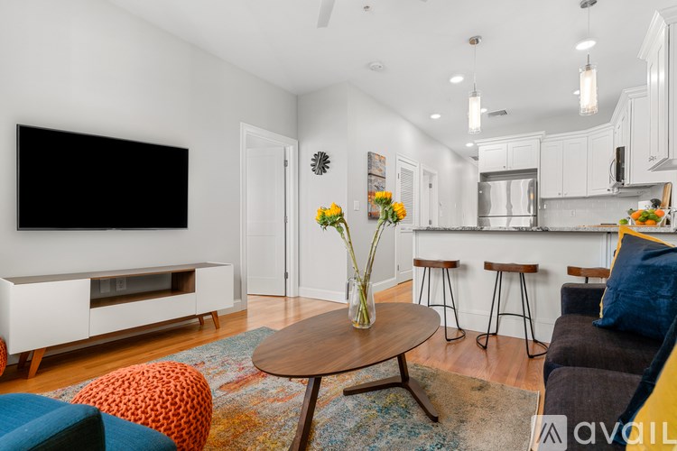 A living room with a television, a bar, and a dining table.
