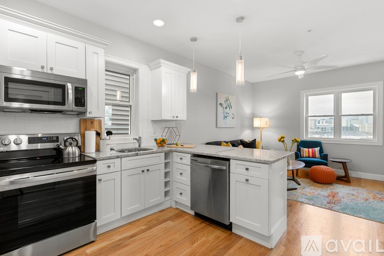 A modern kitchen with white cabinets and a black stove top.