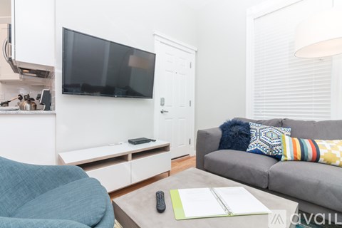 A living room with a grey couch and a television.