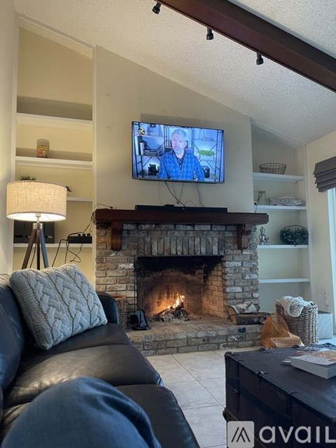 A living room with a fireplace and a television on the wall.