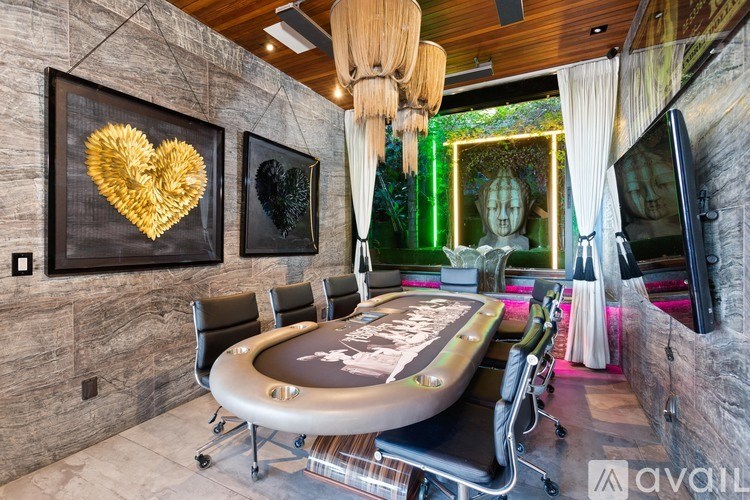 A room with a poker table and chairs.