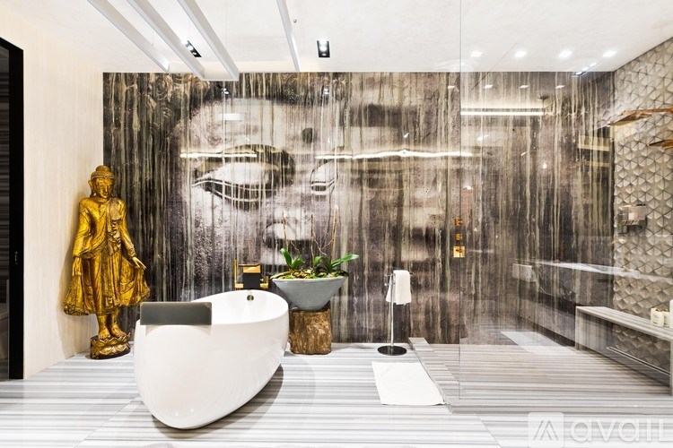 A bathroom with a golden statue and a white bathtub.