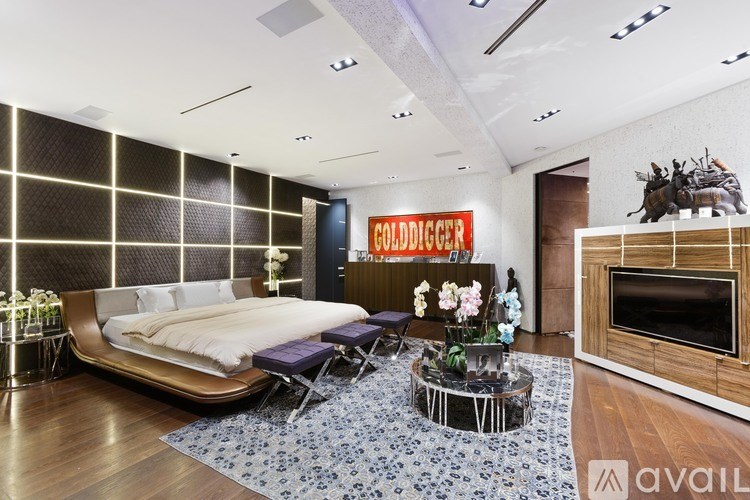 A modern bedroom with a large bed and a TV in the corner.
