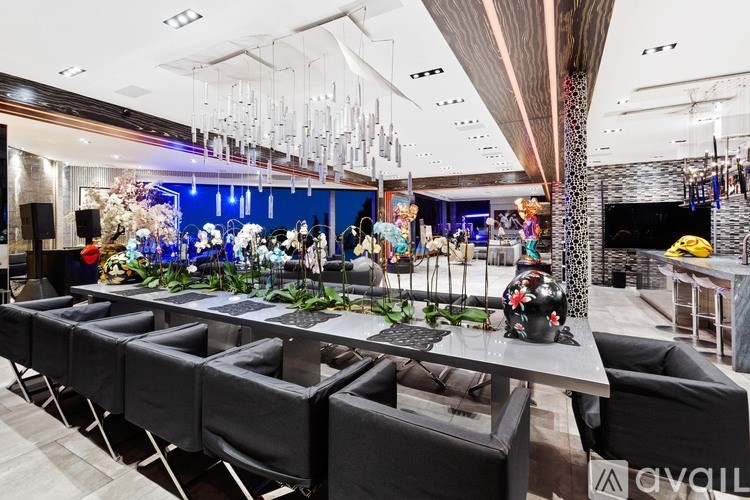 A long table with chairs and a flower arrangement in the middle.