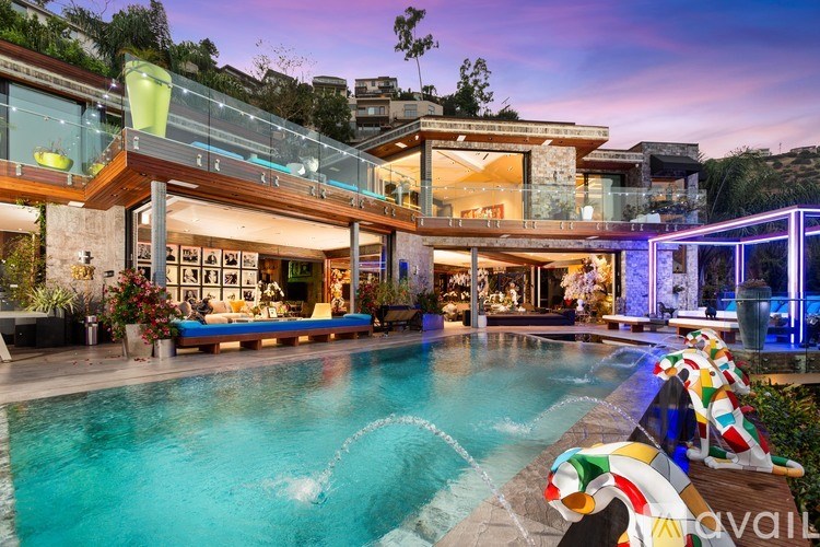A large house with a pool and a glass balcony.