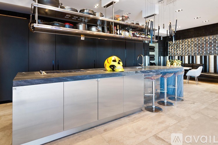 A modern kitchen with a stainless steel counter and a yellow helmet on it.
