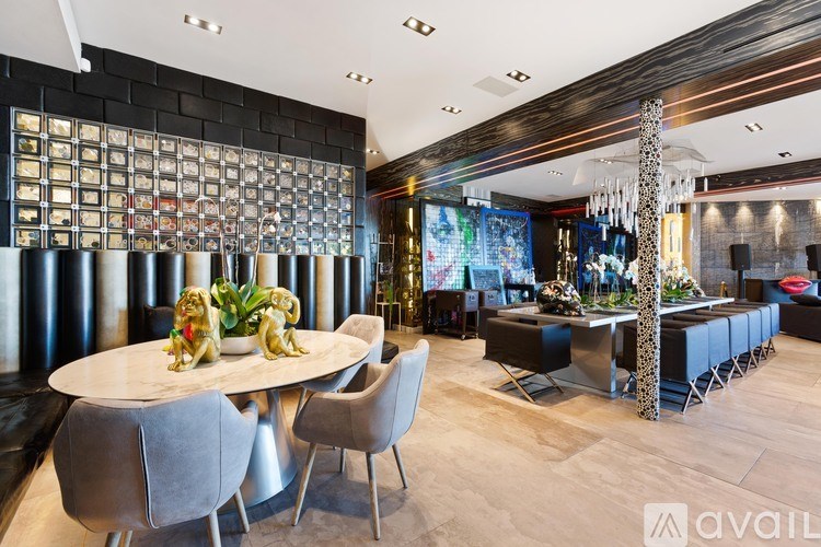 A modern dining room with a round table and grey chairs.
