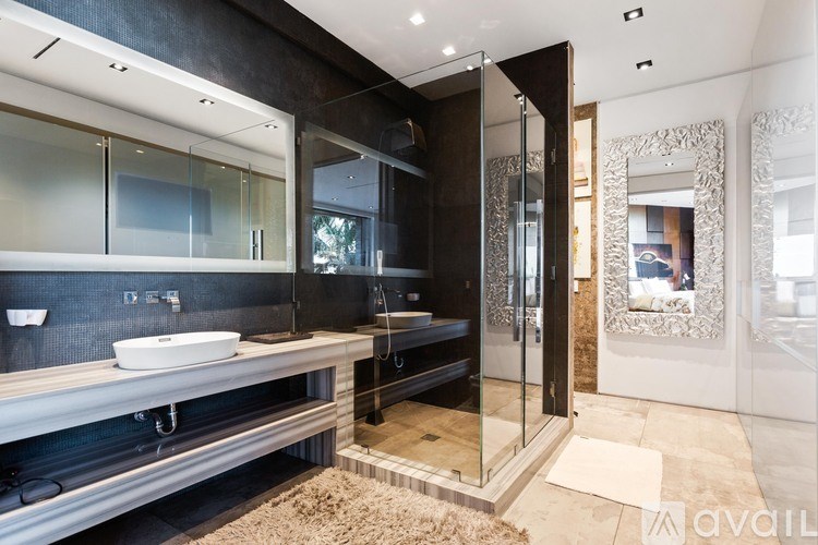 A modern bathroom with a glass shower stall and a sink.