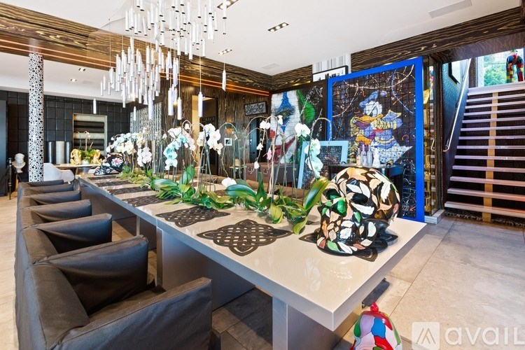 A long table with a white top and a black patterned border is surrounded by brown leather chairs.