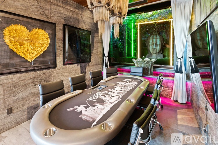 A room with a poker table and chairs.