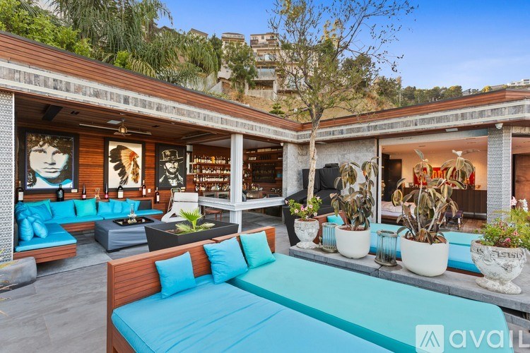 A modern outdoor seating area with a blue sofa and wooden furniture.