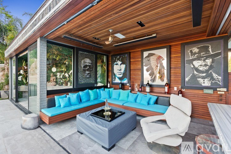 A modern outdoor living space with a blue couch and a coffee table.