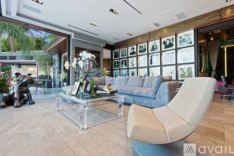 A modern living room with a glass coffee table and a blue sofa.