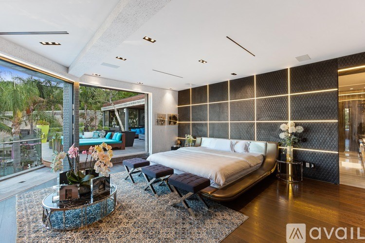 A modern bedroom with a large bed and a view of the outdoors.